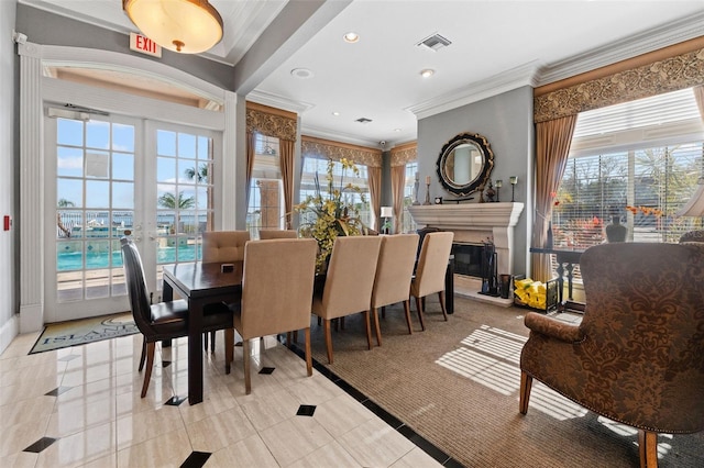 1203 Bay Club Cir Unit 1203, Tampa, FL 33607 - dining space with crown molding, healthy amount of natural light, french doors, a glass covered fireplace, and light tile patterned floors