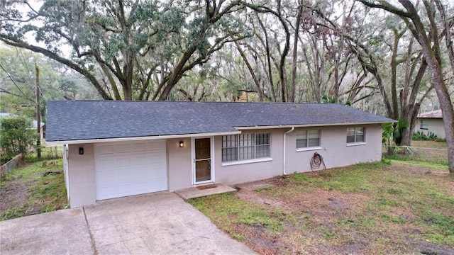 single story home with a garage and a front lawn