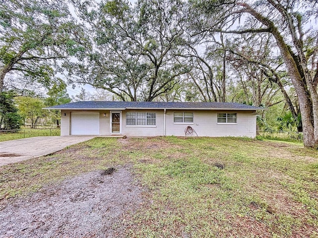 ranch-style home featuring a garage and a front lawn