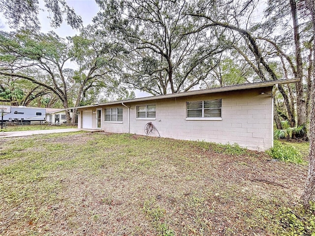 ranch-style house featuring a garage and a front lawn