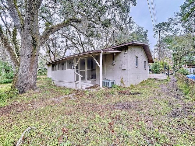 rear view of house with a sunroom and central AC unit