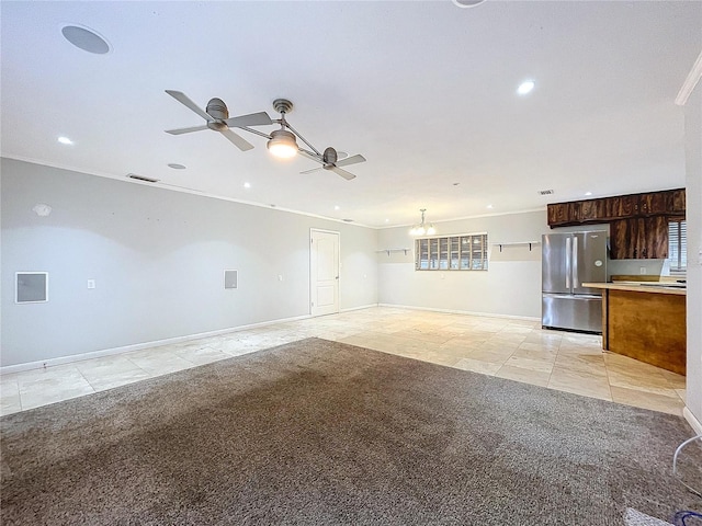 unfurnished living room featuring crown molding, ceiling fan with notable chandelier, and light carpet