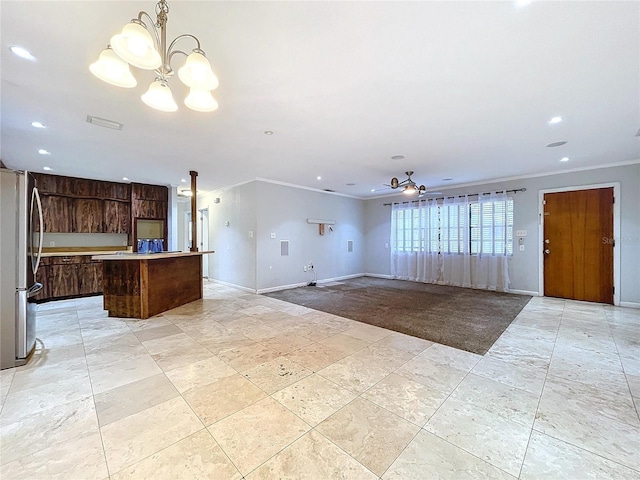 kitchen with dark brown cabinetry, stainless steel refrigerator, ornamental molding, a kitchen island, and pendant lighting