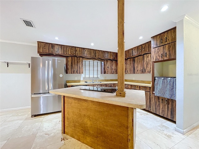 kitchen with a kitchen island, stainless steel refrigerator, sink, black electric stovetop, and crown molding