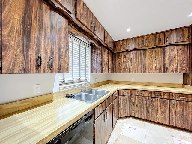 kitchen featuring dark brown cabinetry, black dishwasher, and sink