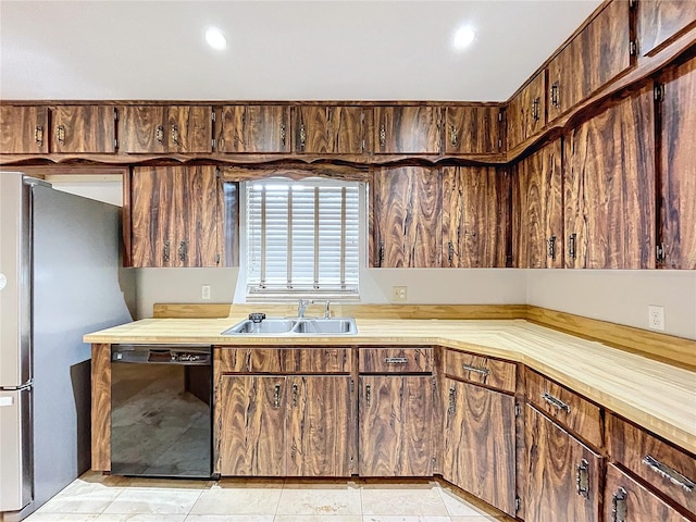 kitchen featuring black dishwasher, sink, stainless steel fridge, and light tile patterned floors