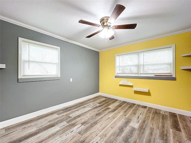 spare room with hardwood / wood-style floors, ornamental molding, a healthy amount of sunlight, and ceiling fan