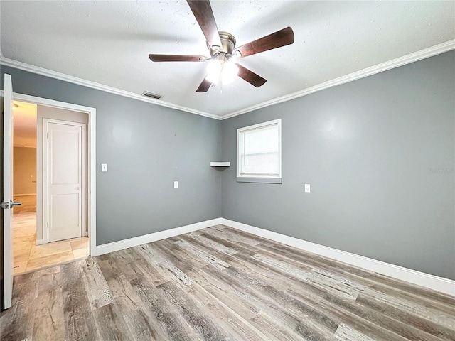 empty room with hardwood / wood-style floors, crown molding, and ceiling fan