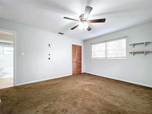 carpeted spare room with ceiling fan