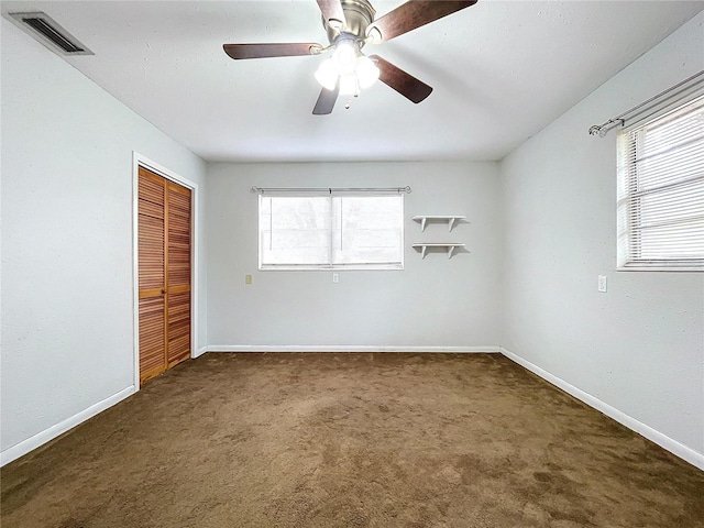 unfurnished bedroom featuring a closet, ceiling fan, and dark colored carpet