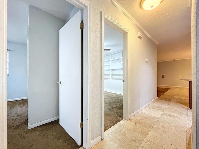 hall with crown molding and light carpet