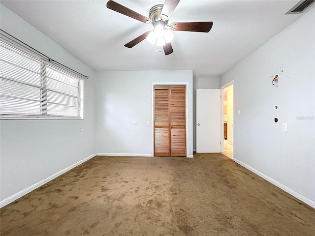 unfurnished bedroom featuring ceiling fan, dark carpet, and a closet