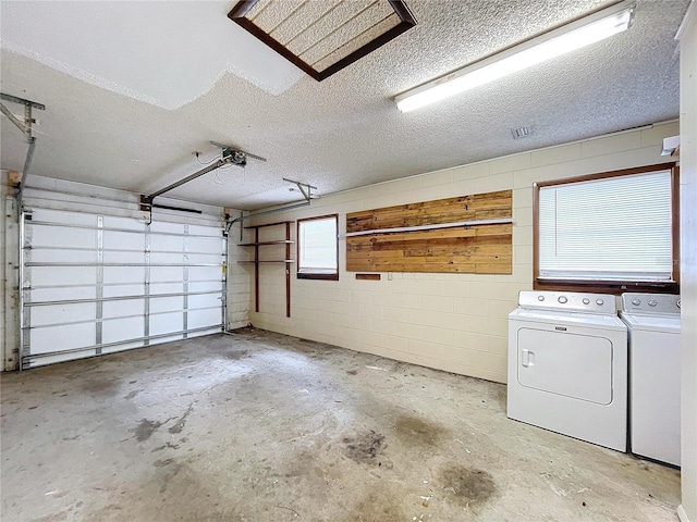 garage with a garage door opener and independent washer and dryer