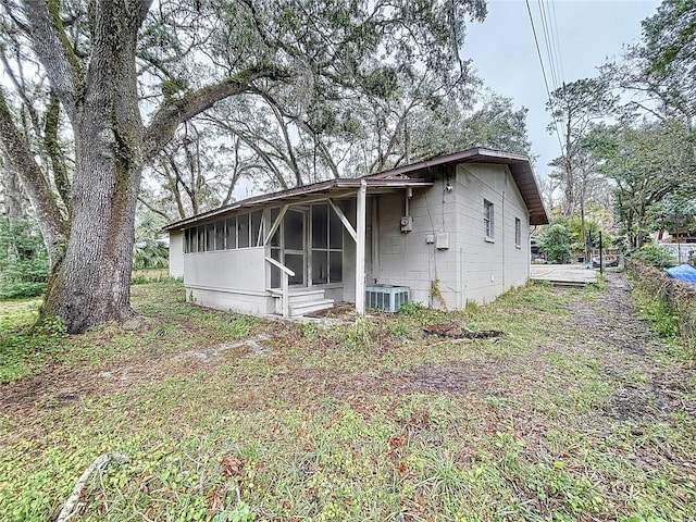 rear view of house with a sunroom and central air condition unit