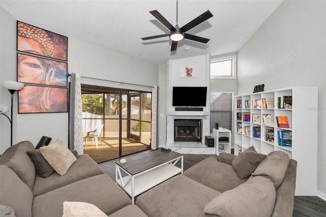 living room featuring high vaulted ceiling, ceiling fan, and a textured ceiling