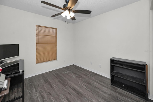 living room with ceiling fan, dark wood-type flooring, and a textured ceiling