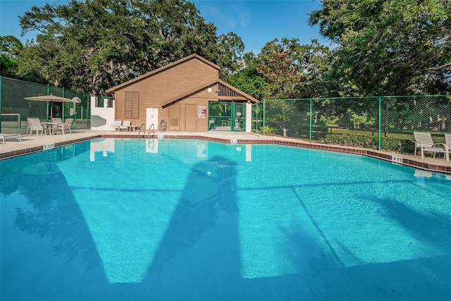 view of swimming pool featuring a patio area and an outdoor structure