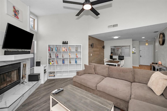 living room featuring hardwood / wood-style flooring, ceiling fan, and a high ceiling