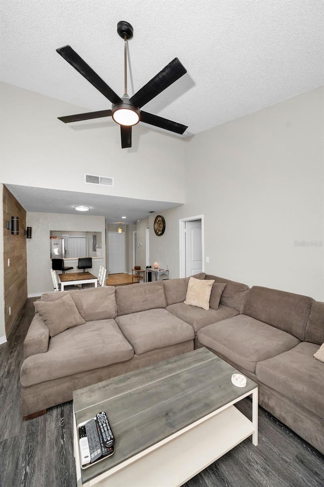 living room with a textured ceiling, lofted ceiling, and dark hardwood / wood-style flooring