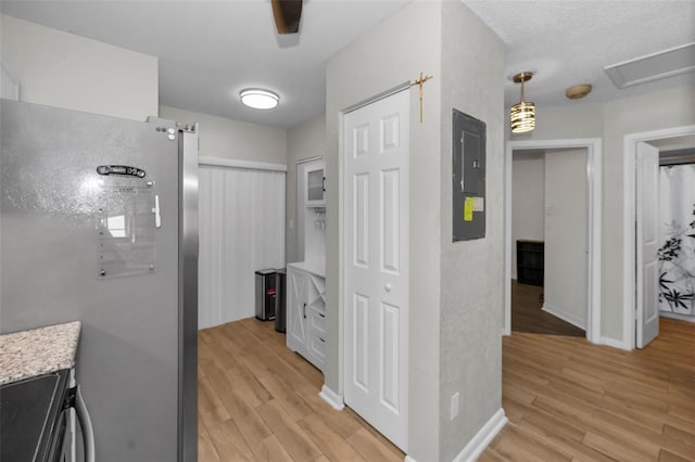 hallway featuring light hardwood / wood-style floors and electric panel