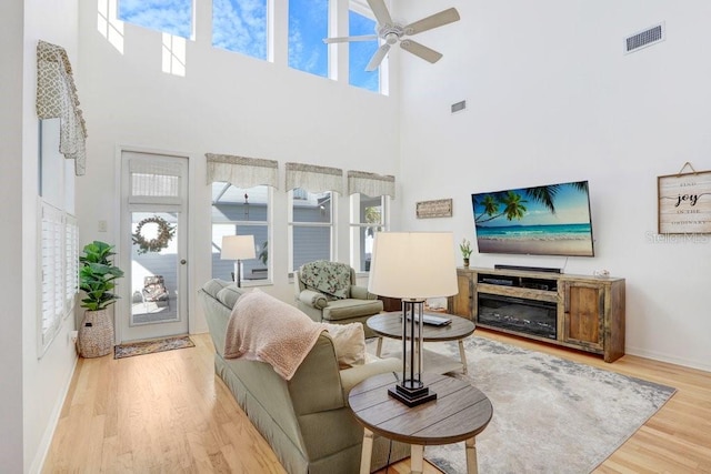 living room featuring ceiling fan and light hardwood / wood-style flooring