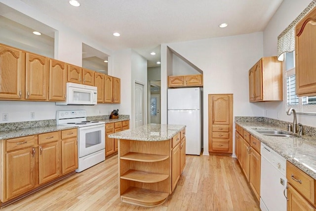 kitchen with a kitchen island, sink, light stone counters, and white appliances