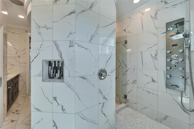 bathroom featuring tiled shower, ornamental molding, and vanity