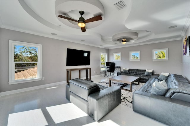 living room featuring ornamental molding, a tray ceiling, and a wealth of natural light