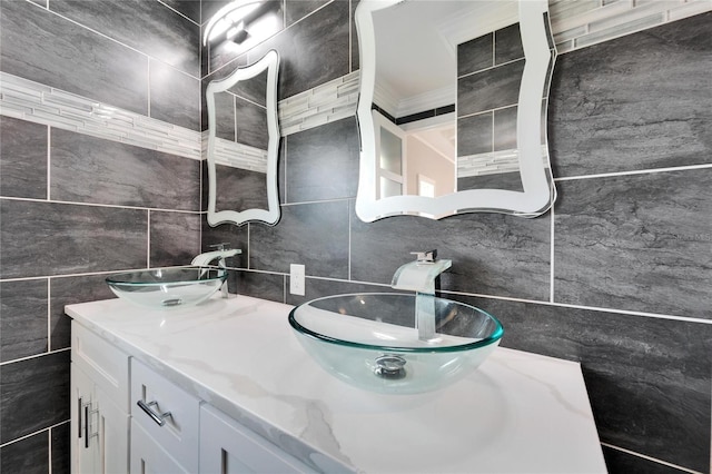 bathroom featuring tasteful backsplash, vanity, crown molding, and tile walls