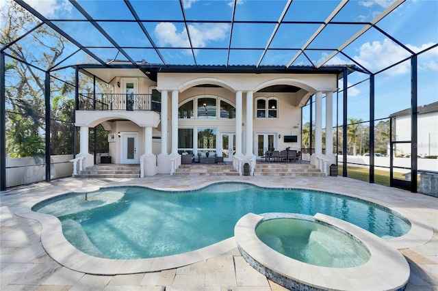 rear view of property featuring french doors, a patio area, a balcony, glass enclosure, and a swimming pool with hot tub