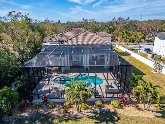 view of pool with a lanai, a patio, and a lawn