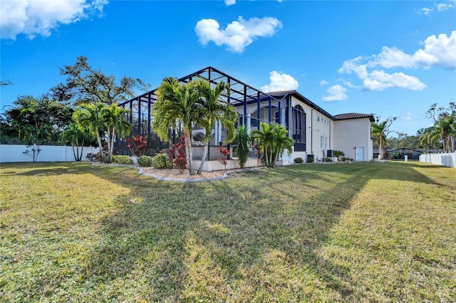 view of front facade featuring a front yard and glass enclosure