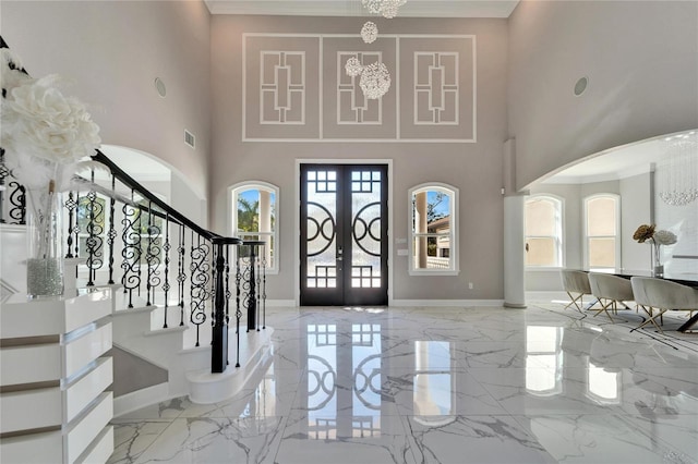 9401 93rd St, Seminole, FL 33777 - foyer entrance featuring arched walkways, light marble finish floors, stairs, a high ceiling, and a chandelier