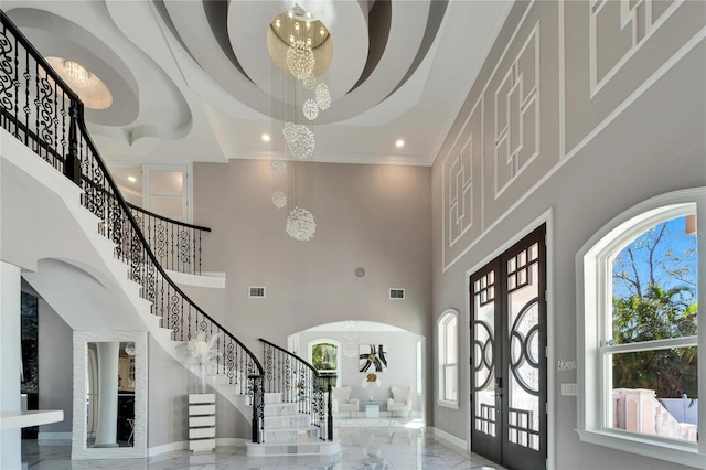 9401 93rd St, Seminole, FL 33777 - entryway with a chandelier, stairs, marble tiled floors, a high ceiling, and arched walkways