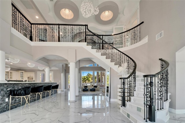 9401 93rd St, Seminole, FL 33777 - foyer entrance with marble tiled flooring, ornate columns, a towering ceiling, baseboards, and stairs