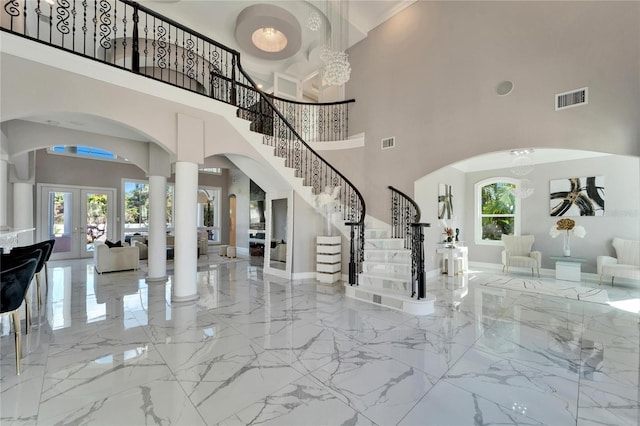 9401 93rd St, Seminole, FL 33777 - entrance foyer featuring marble tiled flooring, arched walkways, stairs, french doors, and a towering ceiling