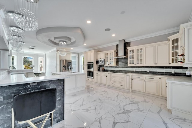 9401 93rd St, Seminole, FL 33777 - kitchen with appliances with stainless steel finishes, wall chimney range hood, a sink, ornamental molding, and an island with sink