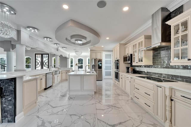 9401 93rd St, Seminole, FL 33777 - kitchen featuring appliances with stainless steel finishes, cream cabinetry, wall chimney exhaust hood, a large island with sink, and a sink