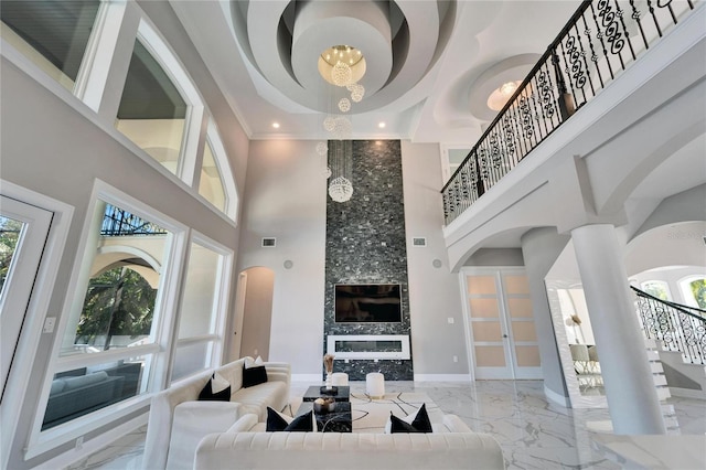 9401 93rd St, Seminole, FL 33777 - living room with a high ceiling, marble tiled floors, healthy amount of natural light, a chandelier, and stairway
