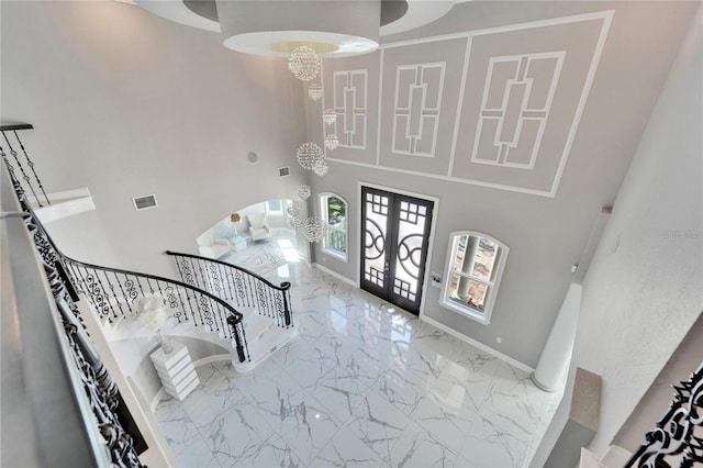 9401 93rd St, Seminole, FL 33777 - entrance foyer with marble tiled floors, a towering ceiling, stairs, arched walkways, and baseboards