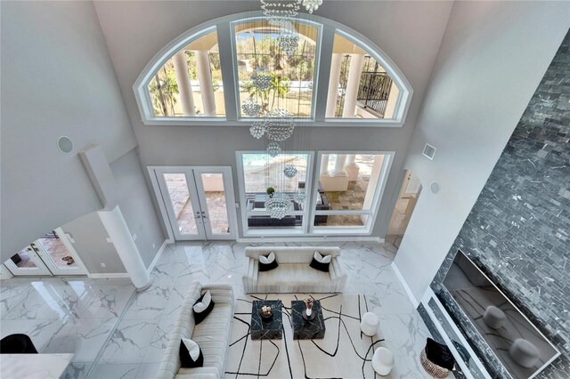 9401 93rd St, Seminole, FL 33777 - living area featuring a chandelier, a high ceiling, marble tiled flooring, and plenty of natural light