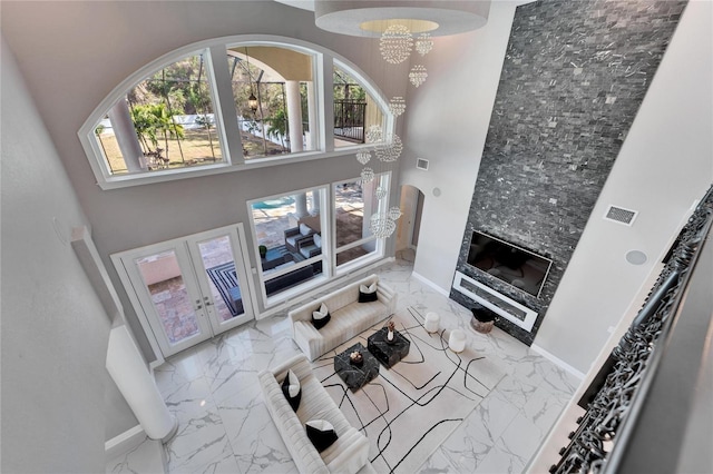 9401 93rd St, Seminole, FL 33777 - living area featuring marble look tile flooring, a towering ceiling, plenty of natural light, french doors, and baseboards