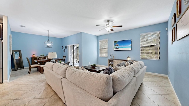 living room with ceiling fan with notable chandelier and light tile patterned floors