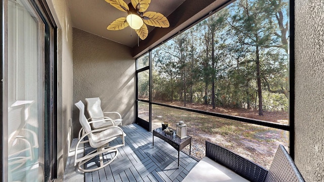 unfurnished sunroom featuring ceiling fan