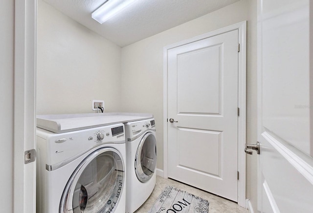 laundry room featuring light tile patterned flooring, separate washer and dryer, and a textured ceiling