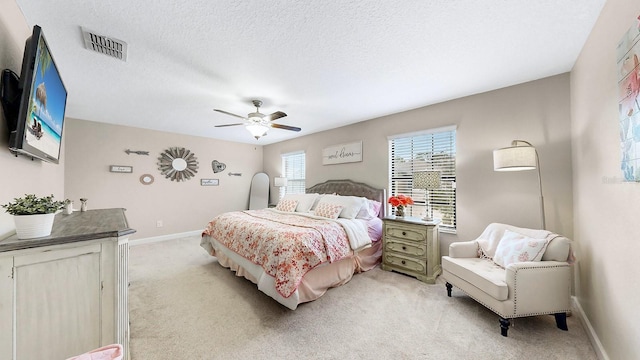 carpeted bedroom with a textured ceiling and ceiling fan