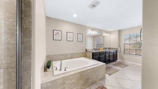 bathroom featuring vanity, tiled bath, and tile patterned floors