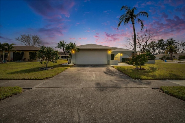 single story home with a garage and a yard