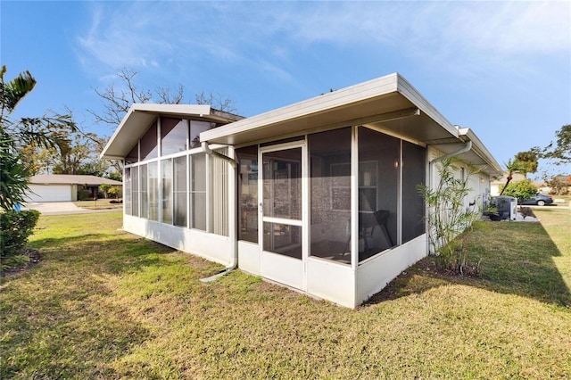 view of side of home featuring a yard and a sunroom