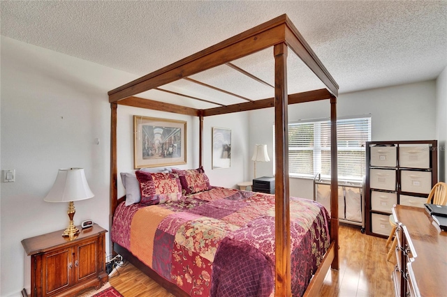 bedroom featuring light hardwood / wood-style flooring and a textured ceiling